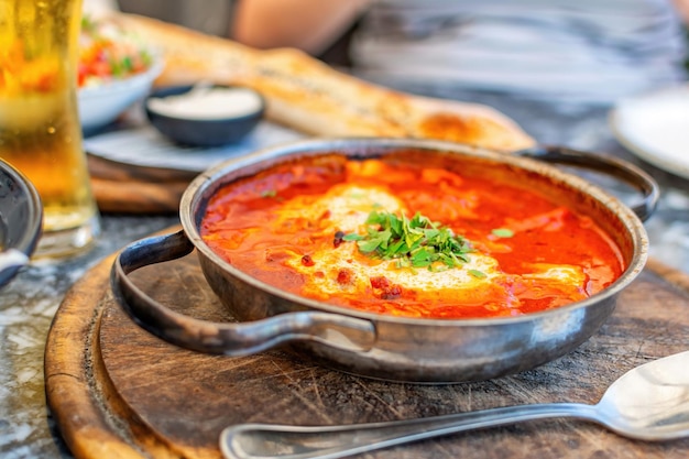 Shakshouka piatto di uova in camicia in salsa di pomodori peperoncino cipolle