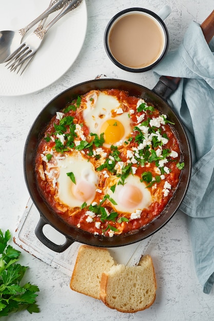 Shakshouka, uova in camicia in salsa di pomodori, olio d'oliva. Cucina mediterranea.