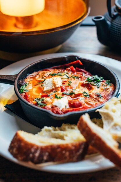 Shakshuka in padella di ferro servito con pane