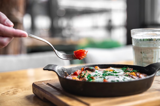 Shakshuka in una padella e un bicchiere di ayran cibo sano e gustoso