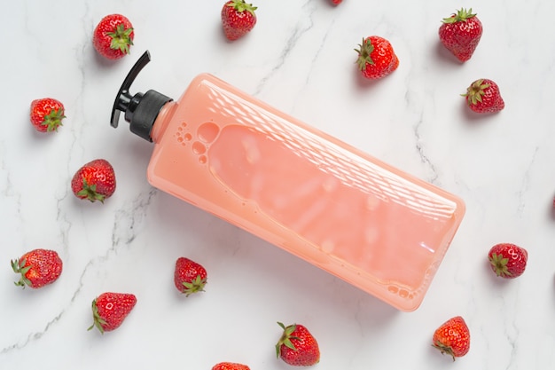 Shampoo alla fragola per bottiglia cosmetica su superficie bianca