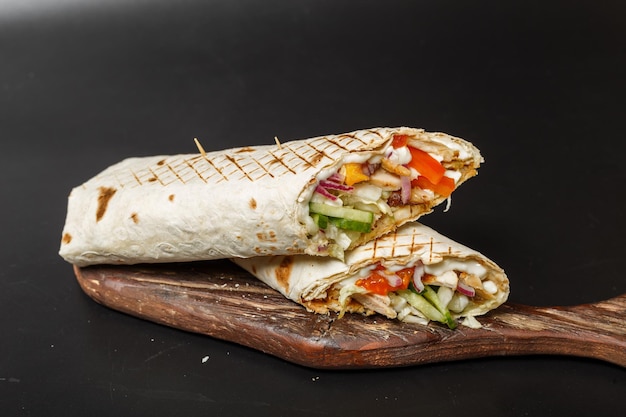 shawarma classico con carne fritta e verdure con sfondo scuro isolato