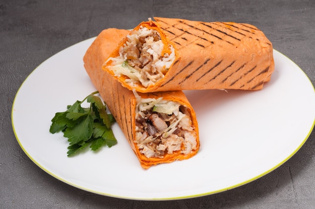 Shawarma o doner kebab con pollo su un piatto bianco