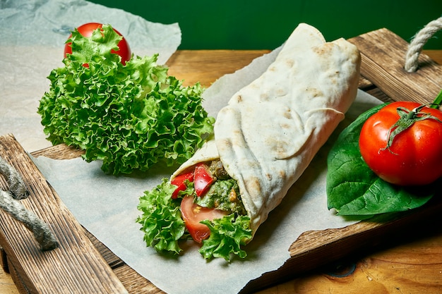 Shawarma vegetariano arriva a fiumi la pita con lattuga, verdure e pomodoro. Cibo gustoso, sano e verde. Cibo da strada vegano