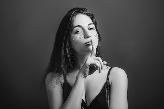 Shh ragazza ritratto Silenzio Mantieni il silenzio Giovane donna con il dito zitto sulle labbra Bianco e nero