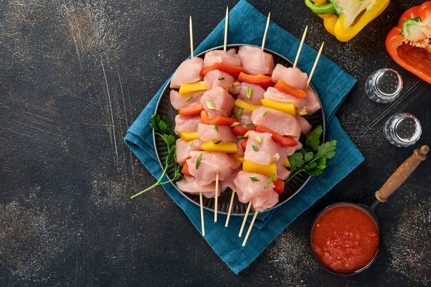 shish kebab crudo su tavola di legno, spezie, erbe e verdure