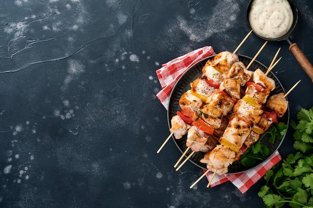 shish kebab di pollo o spiedini di spiedini su tavola di legno, spezie, erbe aromatiche verdure