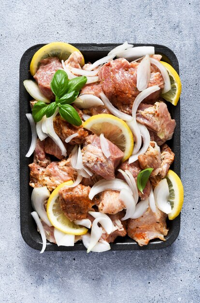 Shish kebab marinato con cipolla e limone. Carne di maiale con spezie su un vassoio.