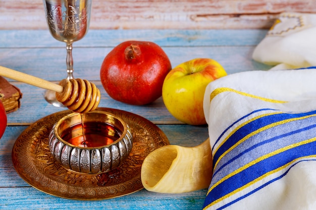 Shofar e tallit con vasetto di miele e frutta