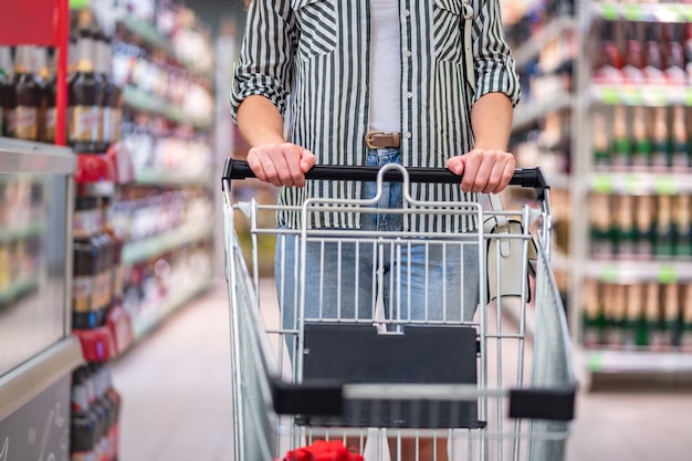 Shopper con carrello della spesa nel corridoio del supermercato. L'acquisto di cibo in drogheria.