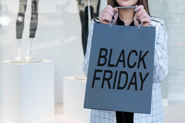 Shopper con sacchetto di carta del Black Friday al centro commerciale