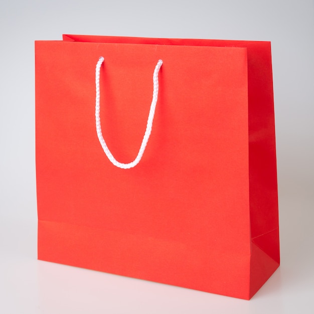 Shopping bag rosso uno sfondo bianco e copia spazio per testo normale o prodotto