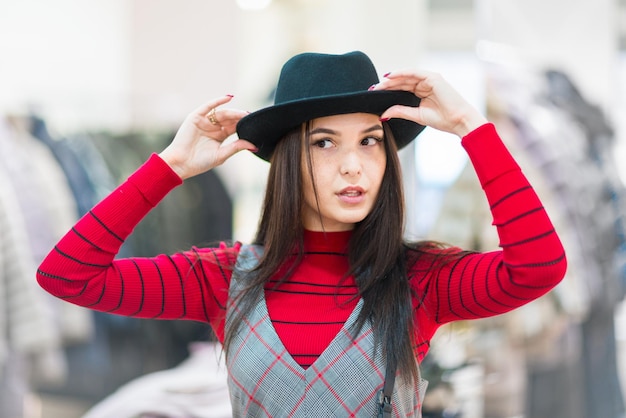 Shopping Bella ragazza che prova un cappello in una boutique