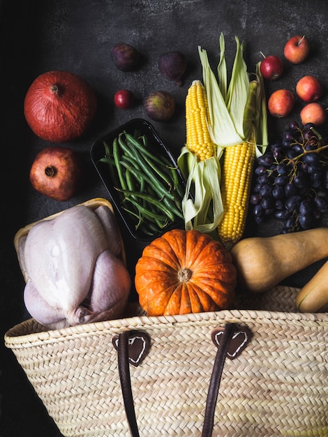 Shopping del Ringraziamento con pollame crudo, verdure e frutta.