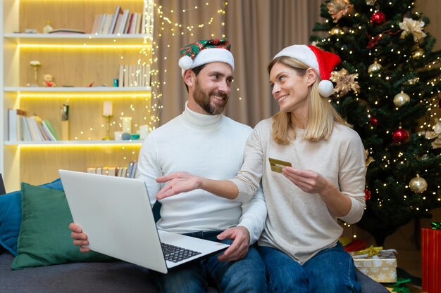 Shopping in linea di famiglia festivo una giovane famiglia felice un uomo e una donna sono seduti a casa sul