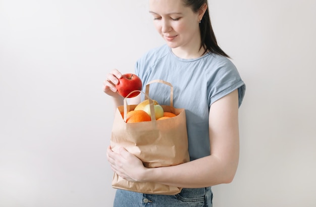 shopping mangiare sano e concetto ecologico primo piano della donna che tiene una borsa ecologica con frutta