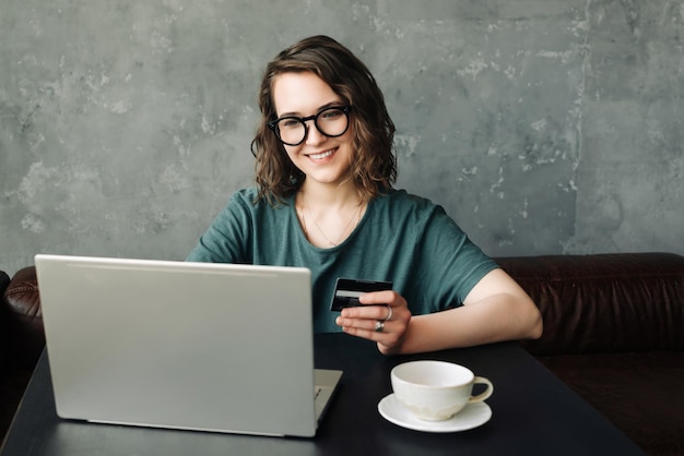 Shopping online senza sforzo Giovane donna che tiene la carta di credito Fare acquisti sicuri su Laptop Compu