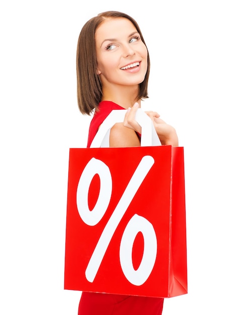 shopping, vendita, regali, natale, concetto di natale - donna sorridente in abito rosso con borse della spesa e segno di percentuale