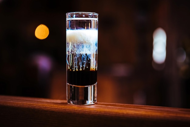 Short drink cocktail a strati con diversi tipi di alcol su un bancone bar in legno in un ristorante