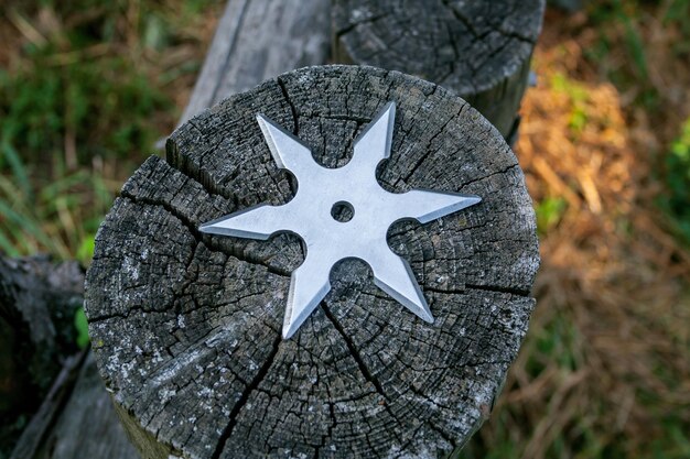 Shuriken stella da lancio arma fredda ninja tradizionale giapponese bloccata su sfondo di legno