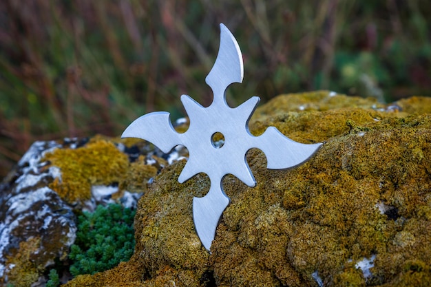 Shuriken stella da lancio arma fredda ninja tradizionale giapponese bloccata su sfondo di legno