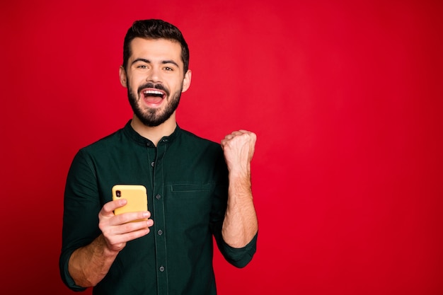 Sì, meglio! L'uomo estatico usa lo smartphone, l'utente dei social media vince la lotteria dei fan online, fa urlare molti follower del blog alza i pugni e indossa la camicia verde