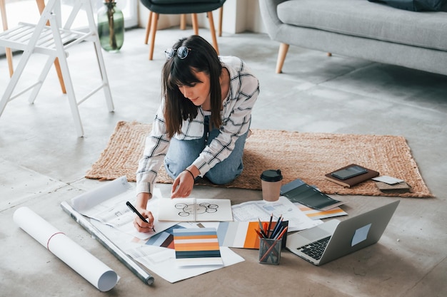 Si siede sul pavimento La giovane lavoratrice freelance è al chiuso in casa durante il giorno