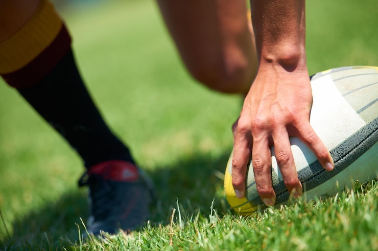 Foto siamo venuti per vincere primo piano della mano di un uomo su un pallone da rugby