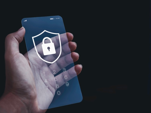 Sicurezza dello smartphone e concetto di privacy. Scudo bianco e lucchetto grafico con numeri per la password sulla schermata di blocco del telefono futuristico in vetro trasparente in mano su sfondo scuro con spazio di copia.