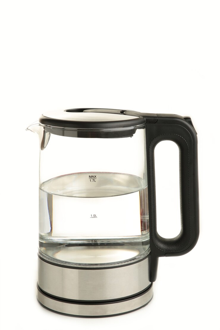 Side view of glass electric kettle with water isolated on white