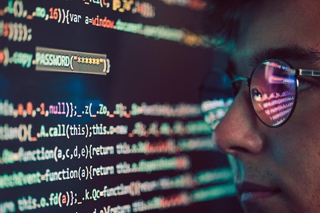 Side view of programmer looking at binary code in office