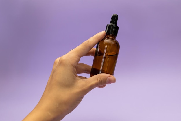 Siero viso su sfondo viola soggetto cosmetici