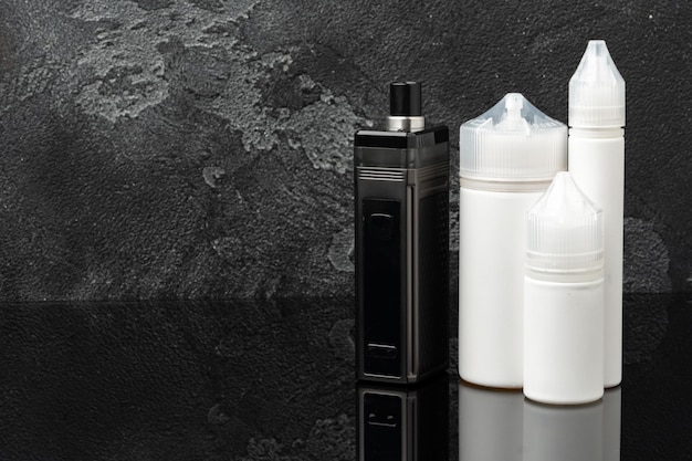 Sigaretta elettronica con bottiglie di liquido di ricarica su sfondo grigio