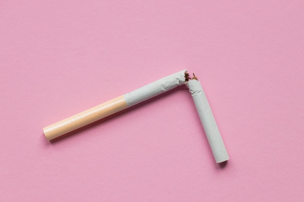 Sigaretta rotta su sfondo rosa