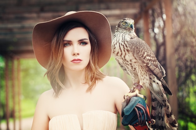 Signora affascinante con cappello vintage con uccello