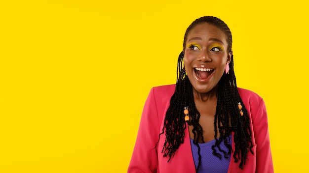 Signora afroamericana che grida per l'eccitazione in posa su sfondo giallo