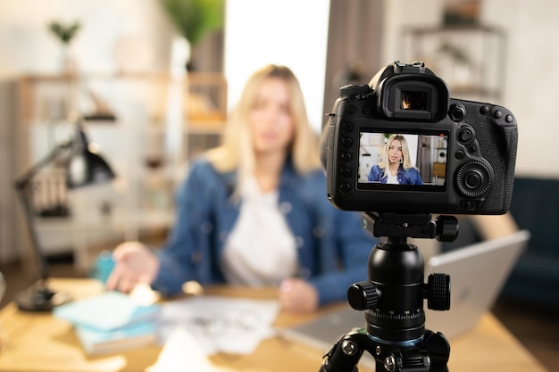 Signora bionda intelligente di affari che filma conferenza educativa sulla macchina fotografica