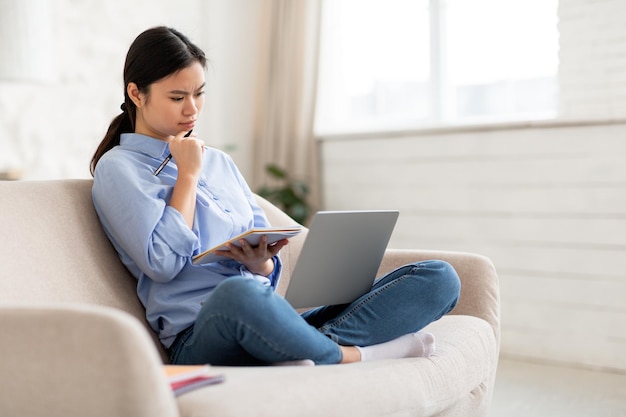 Signora cinese concentrata che frequenta lezione educativa online