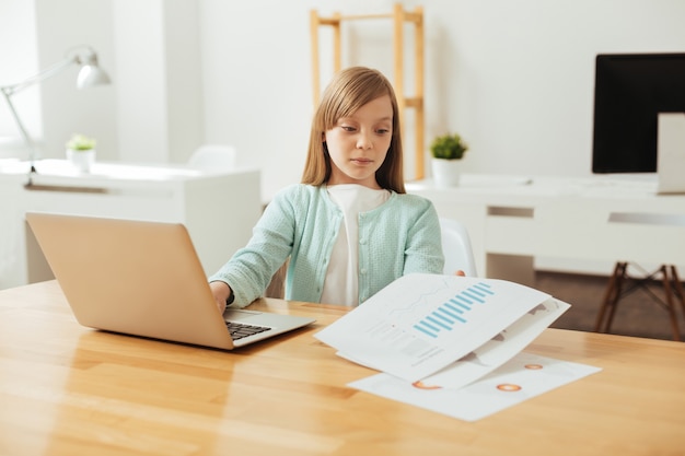 Signora diligente. Bambino dedicato persistente intelligente che studia i dati