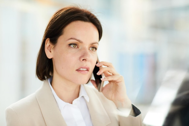 Signora perplessa che parla al telefono