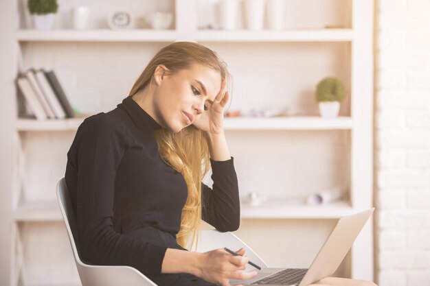 Signora premurosa che usa il computer portatile