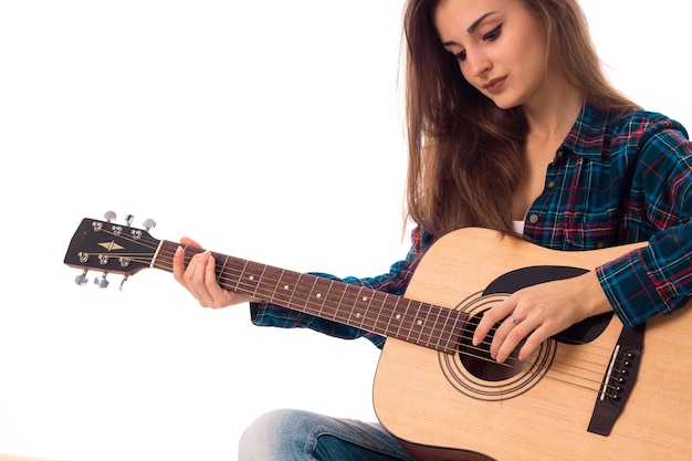 Signora seria con la chitarra in mano con gli occhi chiusi isolati su fondo bianco