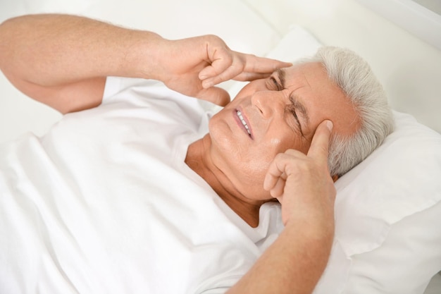 Signore anziano che soffre di dolore in camera da letto