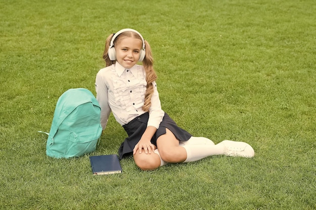 Sii una brava ragazza adolescente per tutta la vita con il libro sull'erba verde bambino bambina leggere libro studio letteratura per bambini nuova tecnologia nella vita digitale giorno della conoscenza educazione scolastica futura