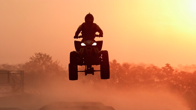 Silhouette ATV o quad. Salta al tramonto