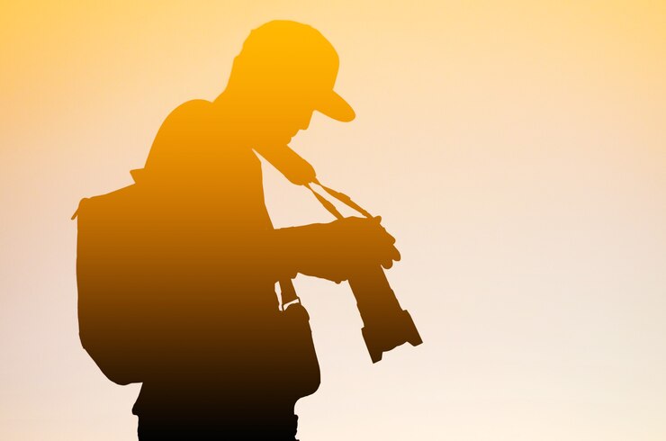Silhouette del fotografo e della sua attrezzatura