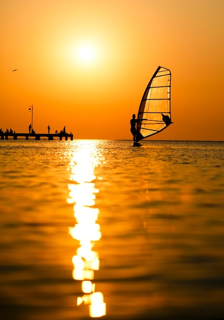 Silhouette del surfista al tramonto che passa