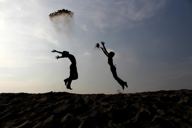 Silhouette di bambini che saltano