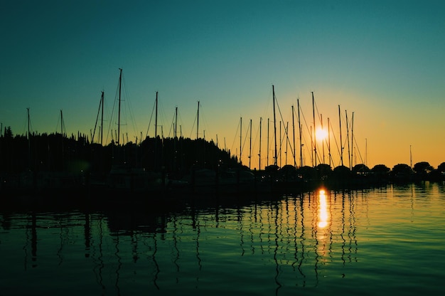 Silhouette di barche sul lago contro il cielo durante il tramonto