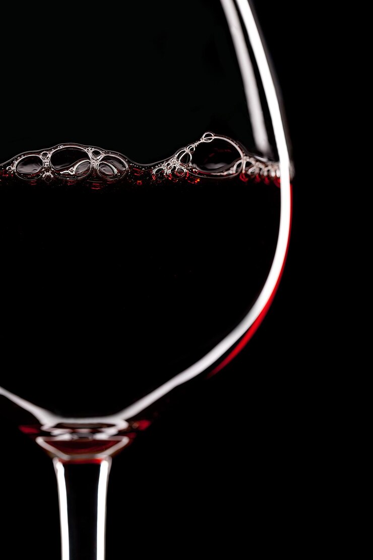 Silhouette di bicchiere di vino rosso su sfondo nero con bolle